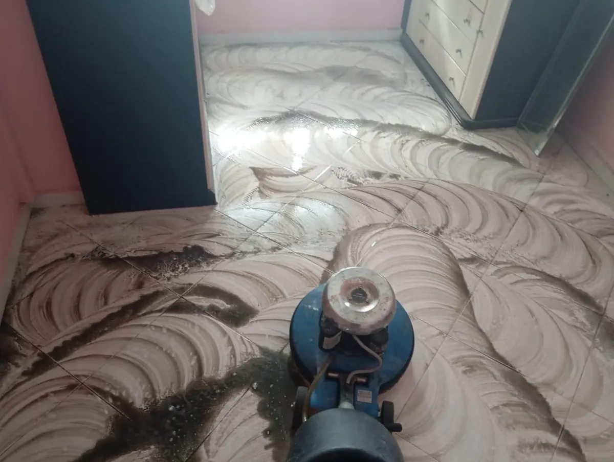 Rotary floor scrubbing machine deep cleaning a tiled floor in a Singapore home
