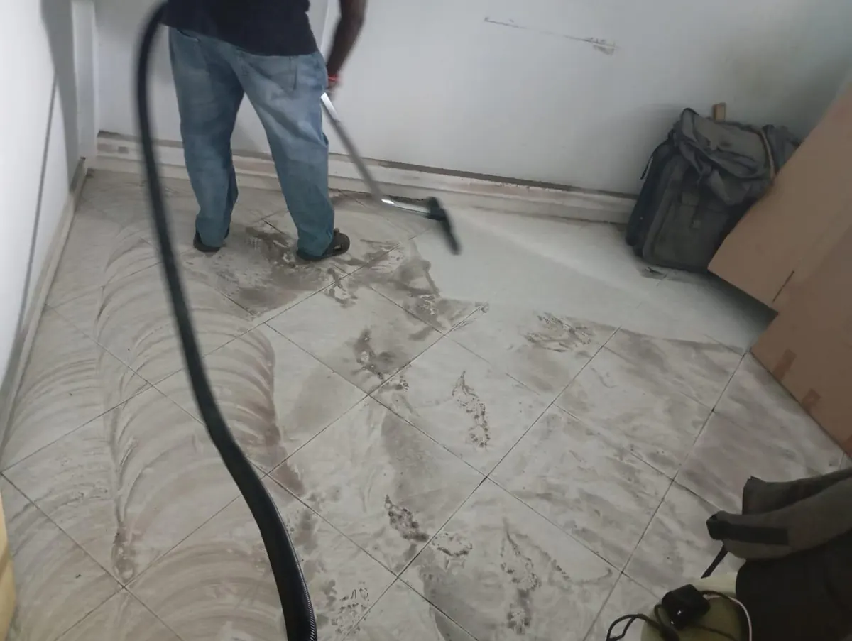 Wet vacuum extraction of a scrubbed tiled floor during move-out cleaning in Singapore