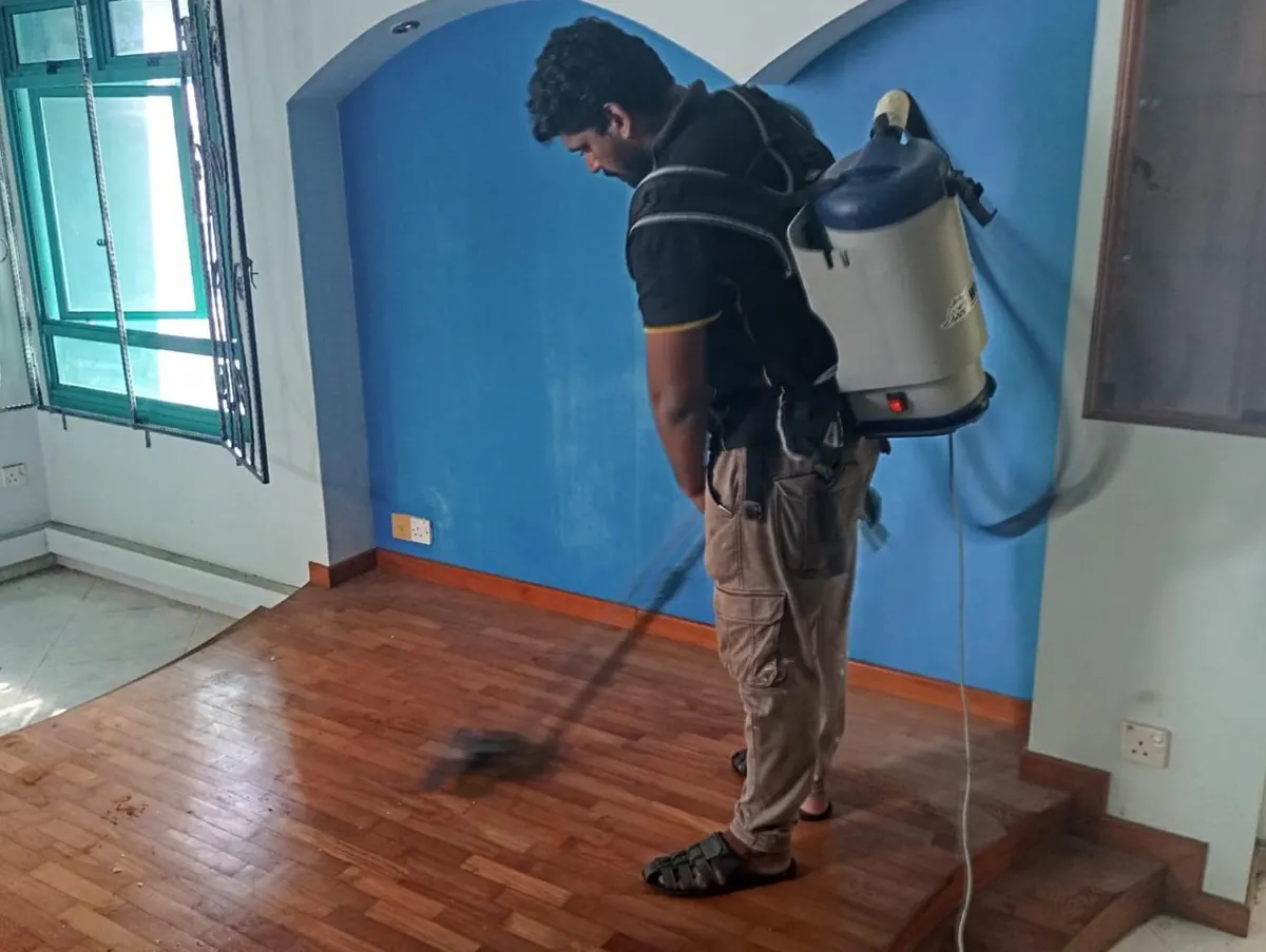 Imperial Services cleaner vacuuming a parquet floor during move-in move-out cleaning in Singapore